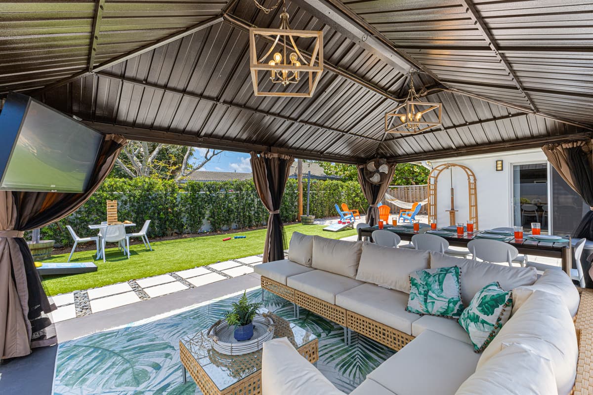 Outdoor Smart TV, comfy couch, and industrial fan — backyard game nights made easy!